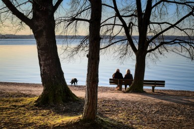 Rotkreuz-Palliative: Paar sitzt auf Bank am See