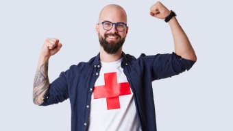 Der Freiwillige Kevin Schatzmann posiert mit einem Rotkreuz-Shirt