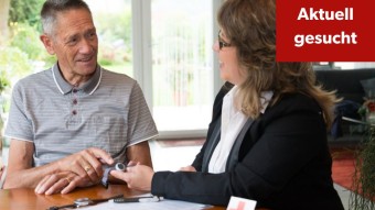 Eine Freiwillige erklärt einem Kunden den Rotkreuz-Notruf